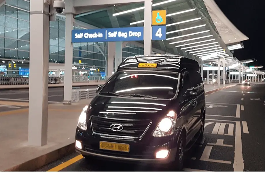 Premium black jumbo deluxe taxi waiting at Incheon Airport terminal at night