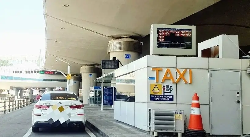Official standard taxi stand and orange taxi at Incheon Airport arrival exit